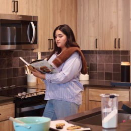 Where recipes come to life and aromas tell tales Woman holding a book in a kitchen